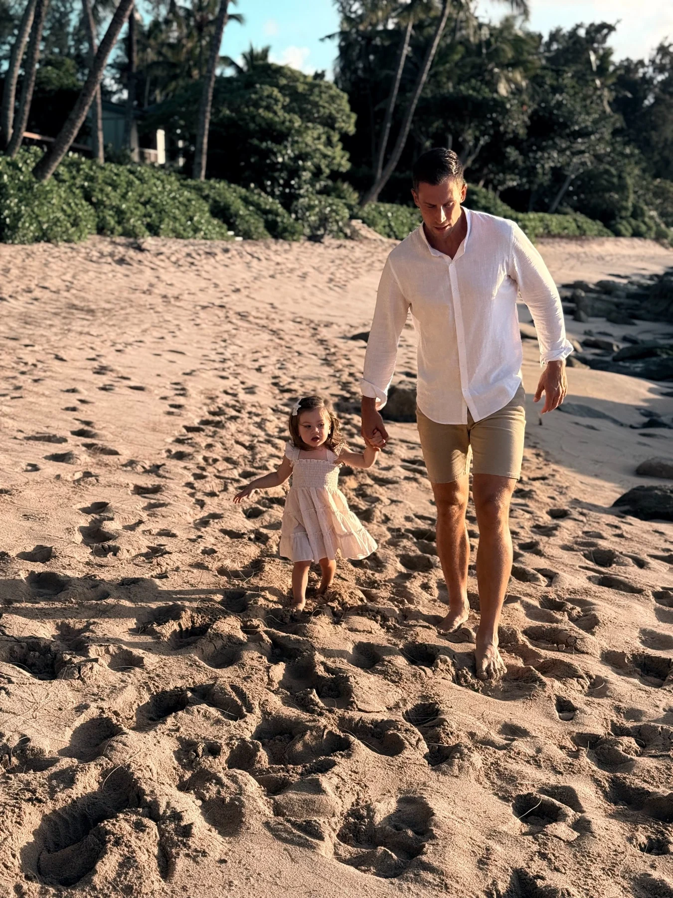 Martin walking on the beach holding his daughter’s hand
